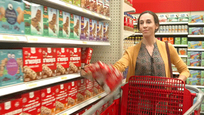 Woman knocking items off shelf into cart